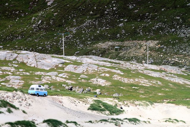 A blue and white campervan on the road